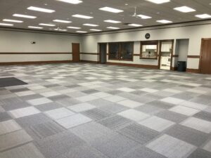 Spacious carpeted room with kitchen facilities.