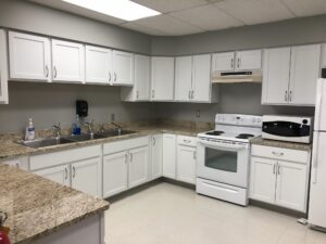Modern kitchen with white cabinets and granite countertops.